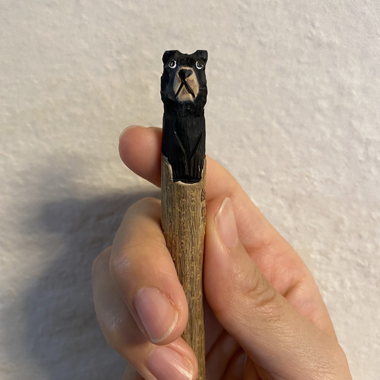 ペンの上部にある木彫りのクマ